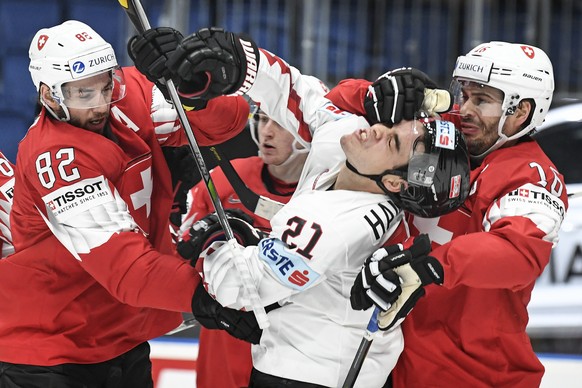 epa07570718 Lukas Haudum of Austria (C), Simon Moser (L) and Raphael Diaz (R) of Switzerland in action during the IIHF World Championship group B ice hockey match between Switzerland and Austria at th ...