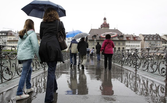 Menschen bei Regenwetter in der Stadt Luzern am Freitag, 31. Mai 2013. Der regnerische und kalte Mai dauert auch an seinem letzten Tag an...(KEYSTONE/Alexandra Wey)