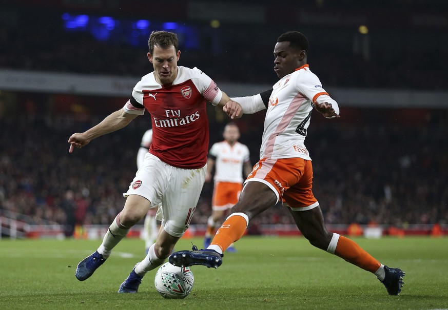 Arsenal&#039;s Stephan Lichtsteiner, left, and Blackpool&#039;s Mark Bola battle for the ball, during the English League Cup 4th round soccer match between Arsenal and Blackpool, at the emirates Stadi ...