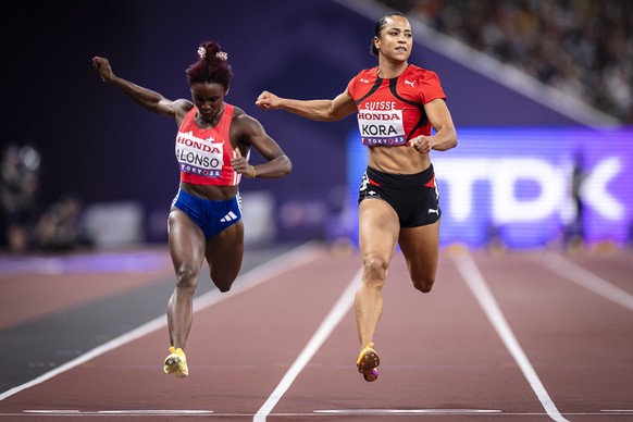 Salome Kora of Switzerland, right, crosses the finish line next to Liranyi Alonso of Dominican Republic, left, in the women&#039;s 100 meters semifinal during day two of the World Athletics Championsh ...