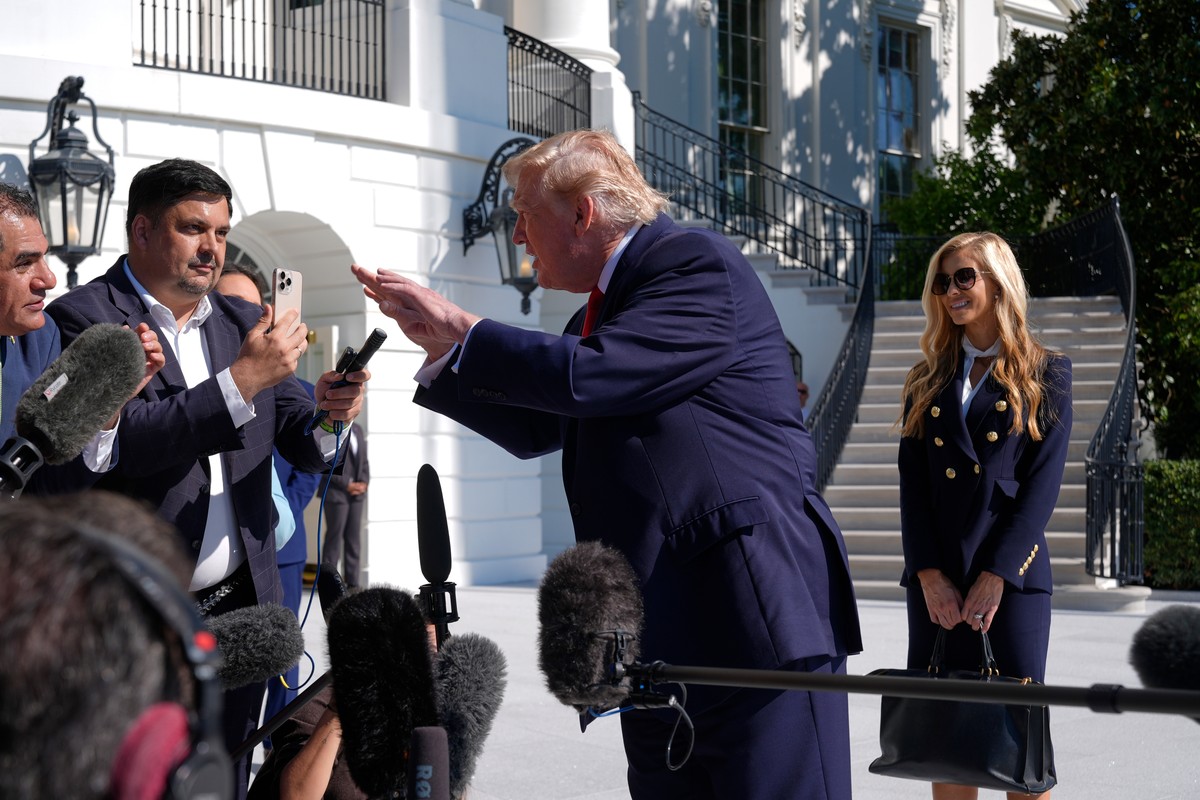 President Donald Trump talks to reporters before boarding Marine One, as White House press secretary Katie Zacharia looks on, on the South Lawn of the White House, Tuesday, Oct. 13, 2026, in Washingto ...