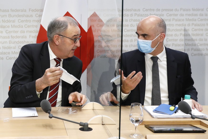 Bundesrat Alain Berset, rechts, diskutiert mit Bundespraesident Guy Parmelin, waehrend einer Medienkonferenz des Bundesrates zur aktuellen Lage im Zusammenhang mit dem Coronavirus, am Mittwoch, 13. Ja ...