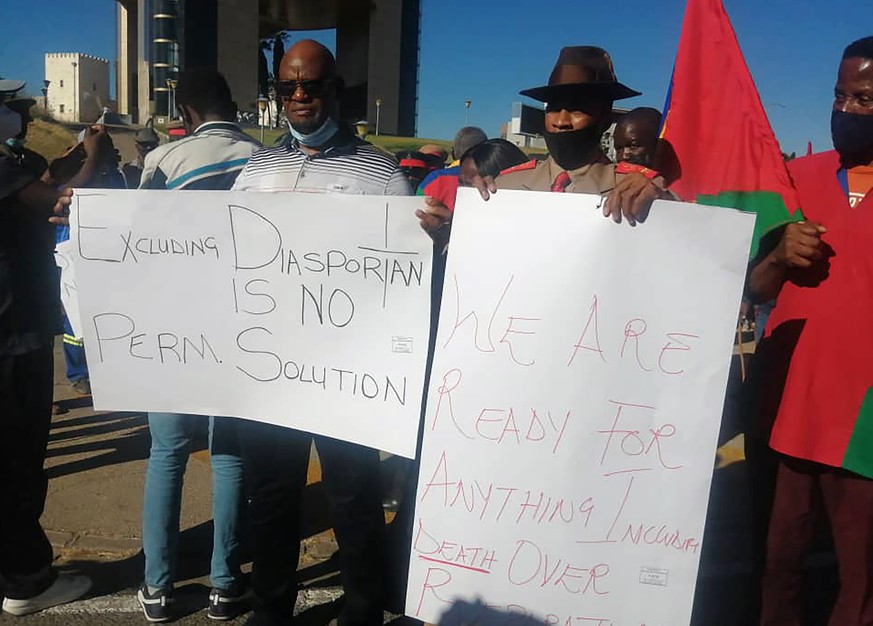 People hold banners as they stage a protest in Windhoek, Namibia, Friday May 28, 2021. Germany has reached an agreement with Namibia that will see it officially recognize as genocide the colonial-era  ...