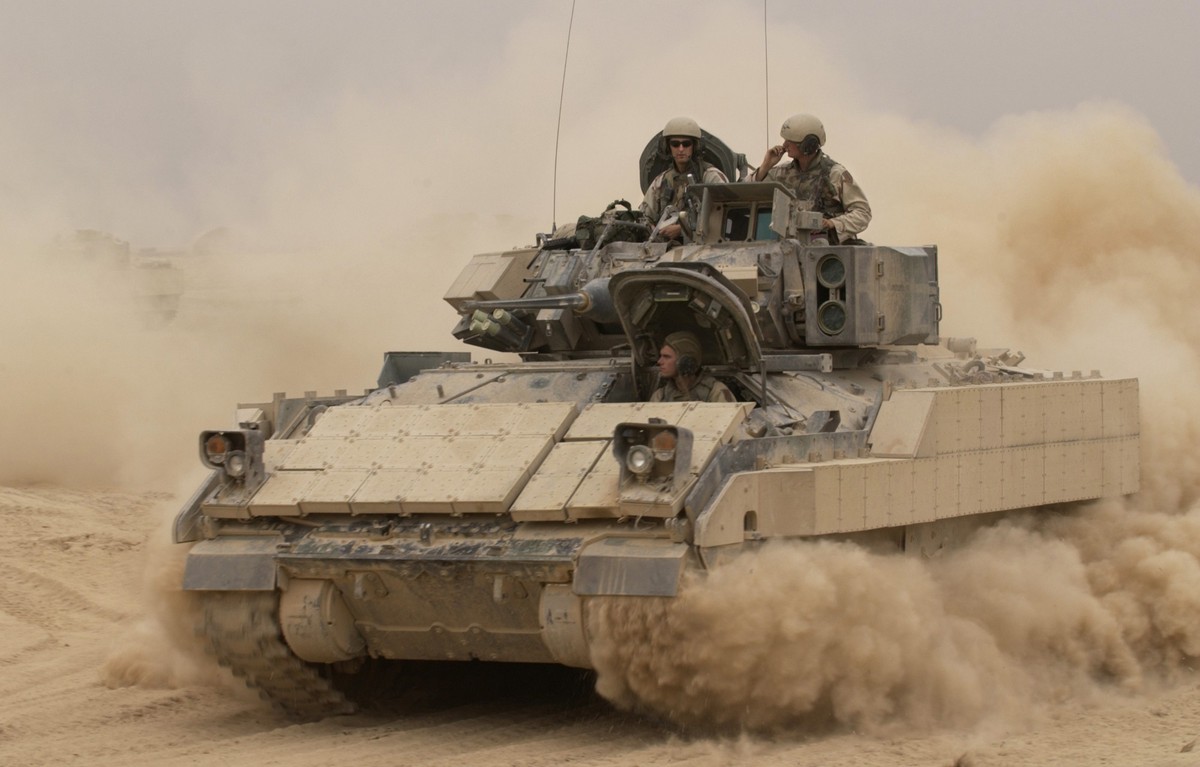 041030-F-2034C-040An M2A2 Bradley Fighting Vehicle kicks up plumes of dust as it leaves Forward Operating Base MacKenzie in Iraq for a mission on Oct. 30, 2004. The Bradley is assigned to Alpha Troop ...