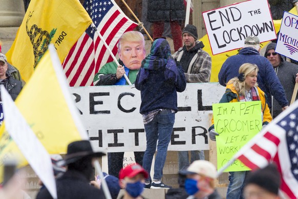 epa08365004 Protesters join in &#039;Operation Gridlock&#039; near the Michigan state Capitol in Lansing, Michigan, USA, 15 April 2020. The protest organizers, The Michigan Conservative Coalition and  ...