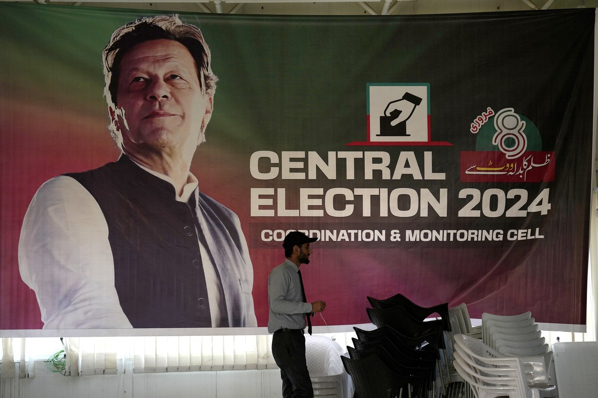 Un supporter passe devant une affiche de l'ex-premier ministre pakistanais Imran Khan, dans les locaux de son parti, à Islamabad.