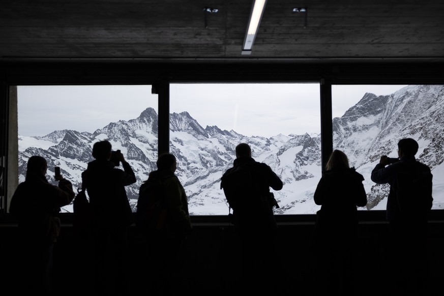 Touristen fotografieren die Gletscherwelt bei der Station Eismeer, am Freitag, 21. Maerz 2025, auf der Fahrt zum Jungfraujoch. Gletscherforscher gaben am 1. Internationalen Tag der Gletscher einen akt ...