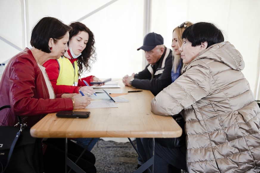 Christine Schraner Burgener, Staatssekretaerin f�r Migration, links, fuellt mit Fluechtlingen aus der Ukraine die Registrierungsformulare beim Bundesasylzentrum Zuerich aus, am Sonntag, 13. Maerz 2022 ...