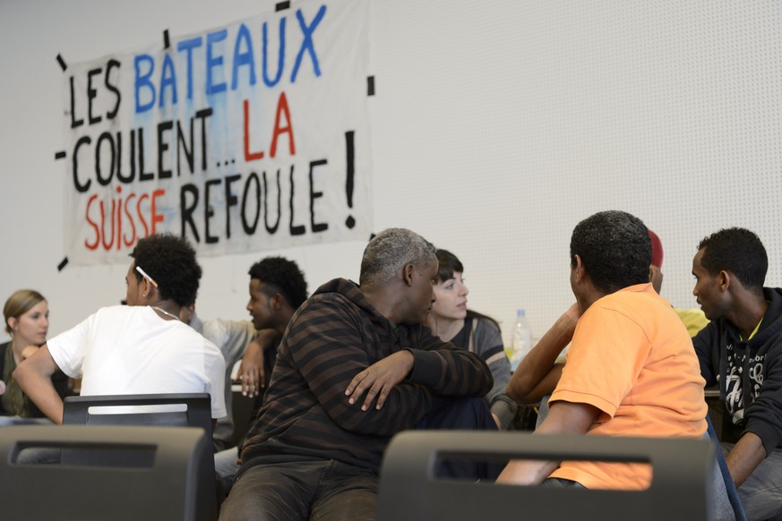 Des refugies sont assis sous une banderole &quot;Les bateaux coulent... La Suisse refoule !&quot; dans l&#039;auditoire de l&#039;UNIL occupe par le collectif R ce lundi 23 novembre 2015 au batiment G ...