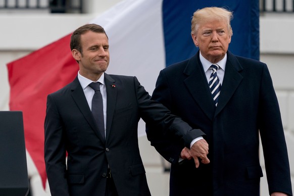 File-This April 24, 2018, file photo shows President Donald Trump and French President Emmanuel Macron hold hands during a State Arrival Ceremony on the South Lawn of the White House in Washington. Tr ...