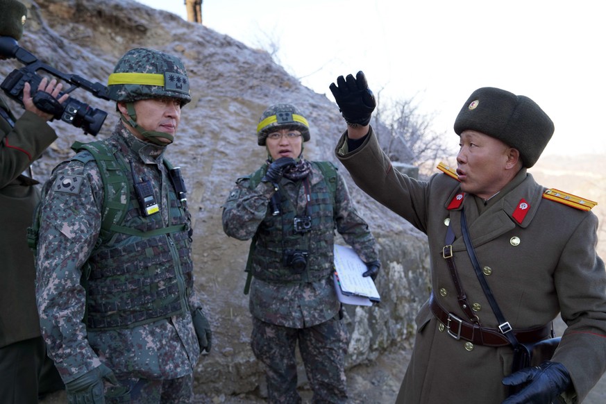 epa07225295 A handout photo made available by the South Korean Ministry of National Defense shows South Korean army colonel Yoon Myung-sik (L) talking with his North Korean counterpart Ri Jong-soo (R) ...