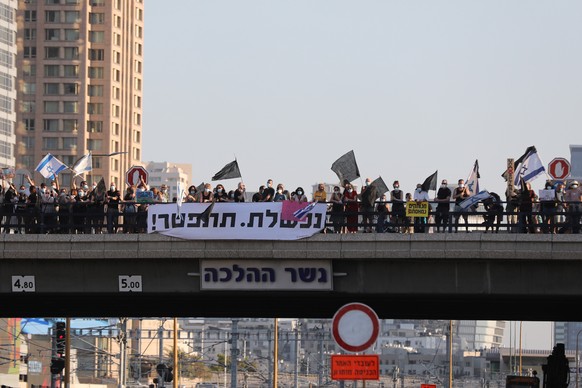 epa08579172 Israelis protest against Israeli Prime Minister Benjamin Netanyahu on a bridge in Ayalon Highway, Israel, 01 August 2020. Netanyahu faces an ongoing trial with indictments filed against him by the State Attorney's Office on a charges of fraud, bribery, and breach of trust.  EPA/ABIR SULTAN