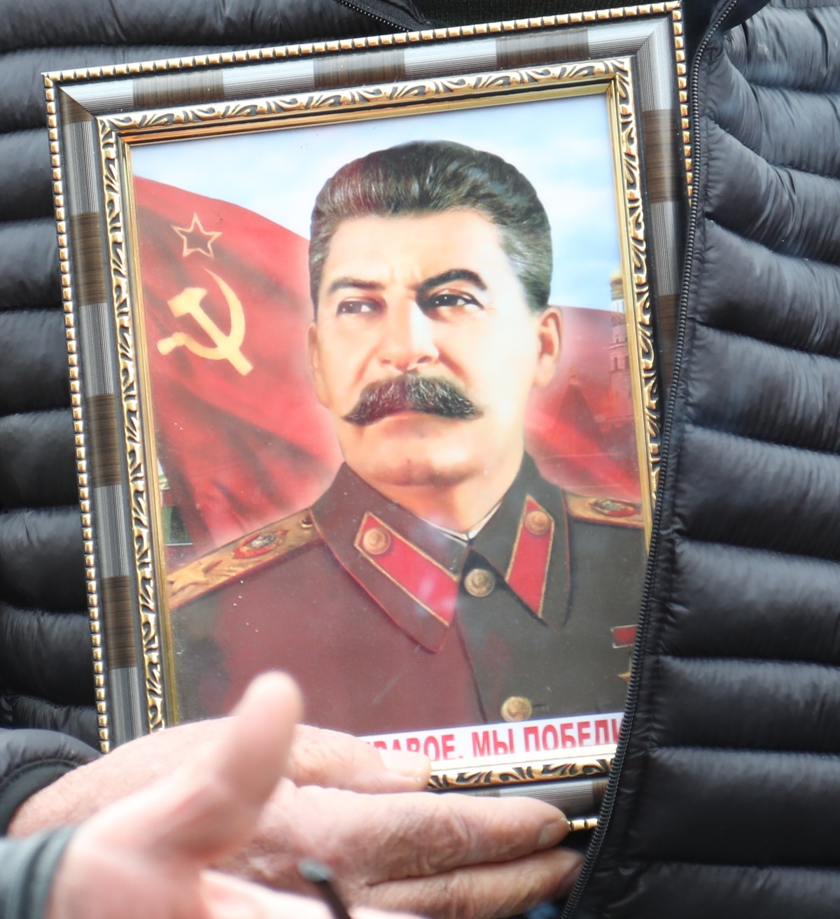 epa07243149 Georgian Stalinist holds portraits of Soviet dictator Joseph Stalin during the annual celebration of Stalin's birthday in his native town of Gori, about 80 km west of Tbilisi, Georgia ...