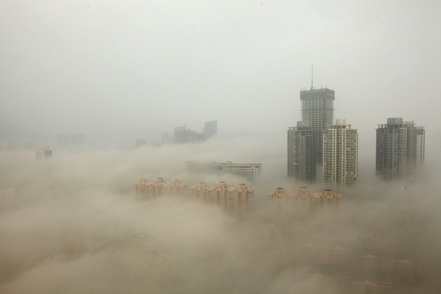 LIANYUNGANG, CHINA - DECEMBER 08: (CHINA OUT) Buildings are shrouded in smog on December 8, 2013 in Lianyungang, China. Heavy smog has been lingering in northern and eastern parts of China since last  ...