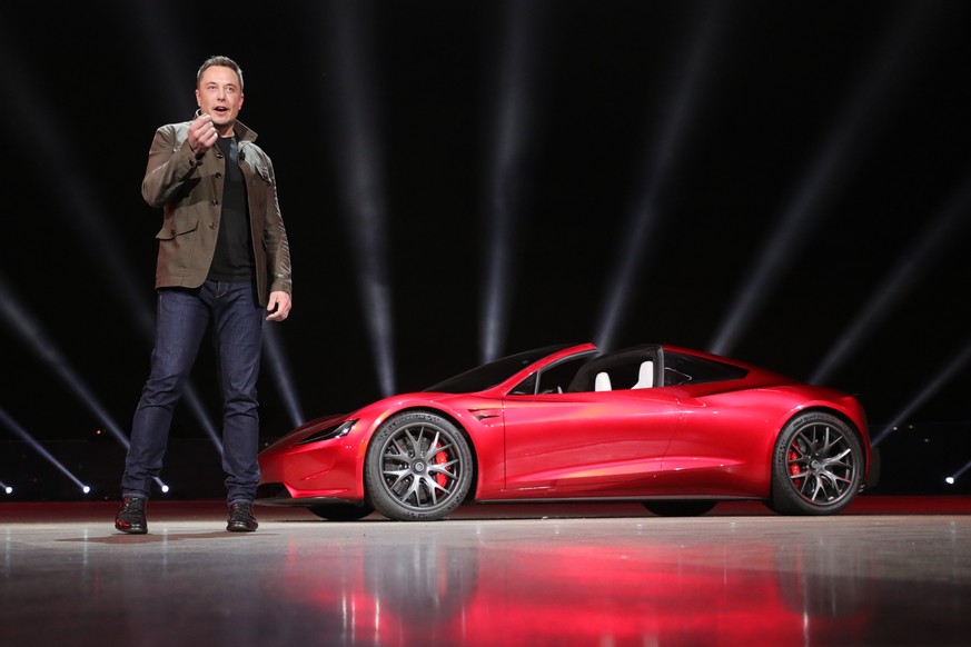 epa06335606 A handout photo made available by Tesla 16 November 2017, showing Tesla founder Elon Musk presenting the new Roadster electric sports vehicle (on background), presented to media 16 Novembe ...