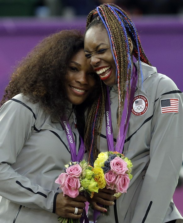 FILE - Serena Williams, left, and Venus Williams of the United States laugh together on the podium after receiving their gold medals in women&#039;s doubles at the 2012 Summer Olympics at the All Engl ...