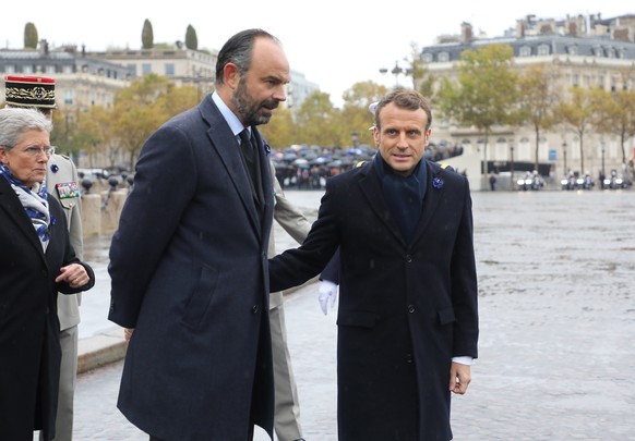 epa07987852 French President Emmanuel Macron (C) and French Prime Minister Edouard Philippe (L) arrive to attend a ceremony at the Arc de Triomphe in Paris, France, 11 November 2019, as part of the co ...