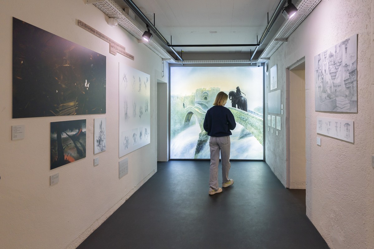Une personne regarde des oeuvres qui sont exposees lors de l'exposition inaugurale "Voyage dans les mondes de John Howe" ce lundi 15 decembre 2025 a la Tour du Fantastique a Neuchatel.  ...