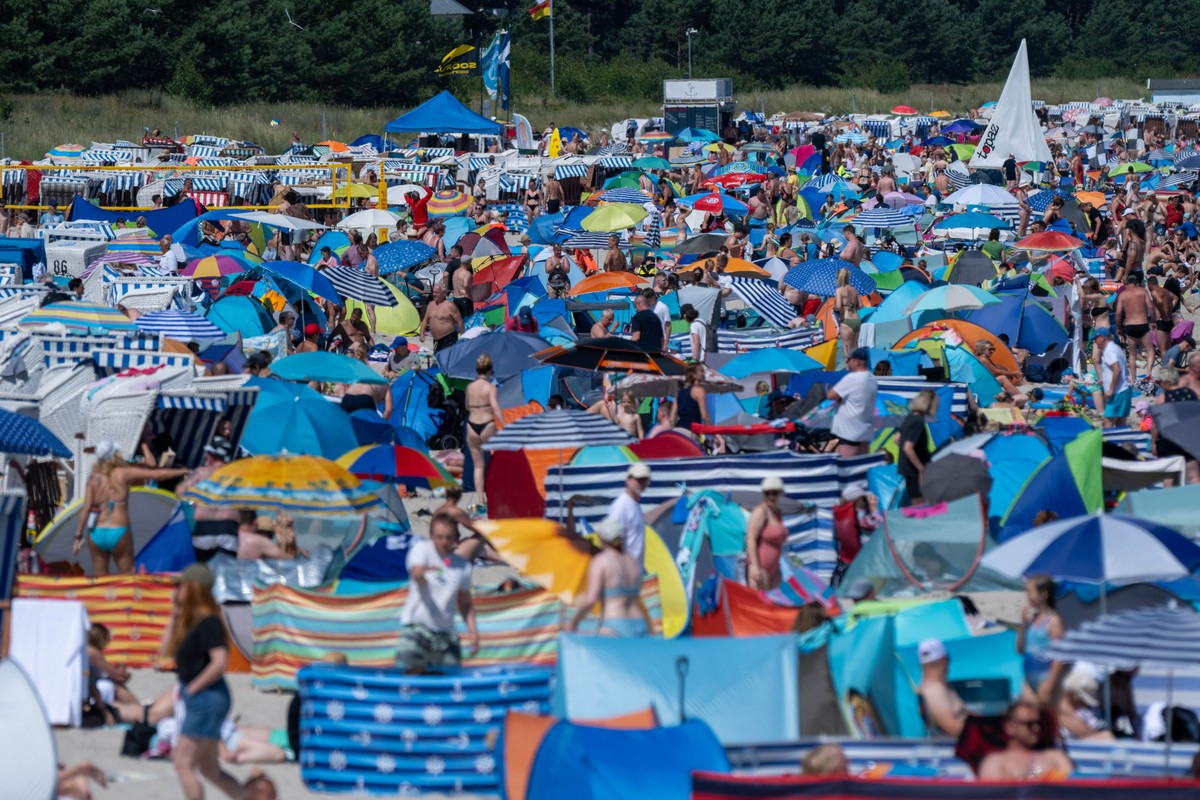 20.07.2024, Mecklenburg-Vorpommern, Binz: Touristen nutzen das hochsommerliche Wetter am Strand auf der Insel R