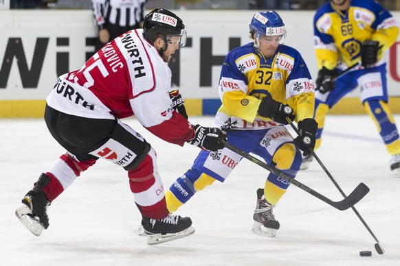 Team Canada's Daniel Vukovic, left, fight for the puck with Davos' Sin Schlaepfer during the game between Team Canada and Switzerland's HC Davos at the 89th Spengler Cup ice hockey tour ...