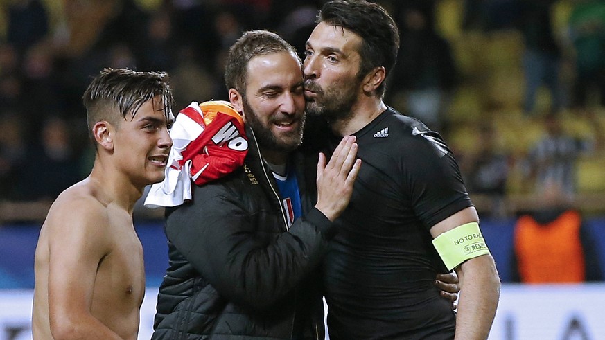 epa05942703 Juventus goalkeeper Gianluigi Buffon (R) hugs his teammate Gonzalo Higuain (C) net to Paulo Dybala (L) after winning the UEFA Champions League semi final, first leg soccer match between AS ...