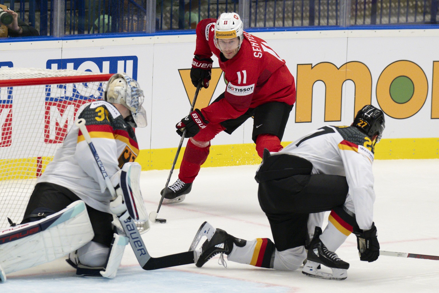 Switzerland&#039;s Sven Senteler, center, in action against Germany&#039;s goalkeeper Harald Grubauer, left, and Germany&#039;s Maksymilian Szuber during the Ice Hockey World Championship quarter fina ...