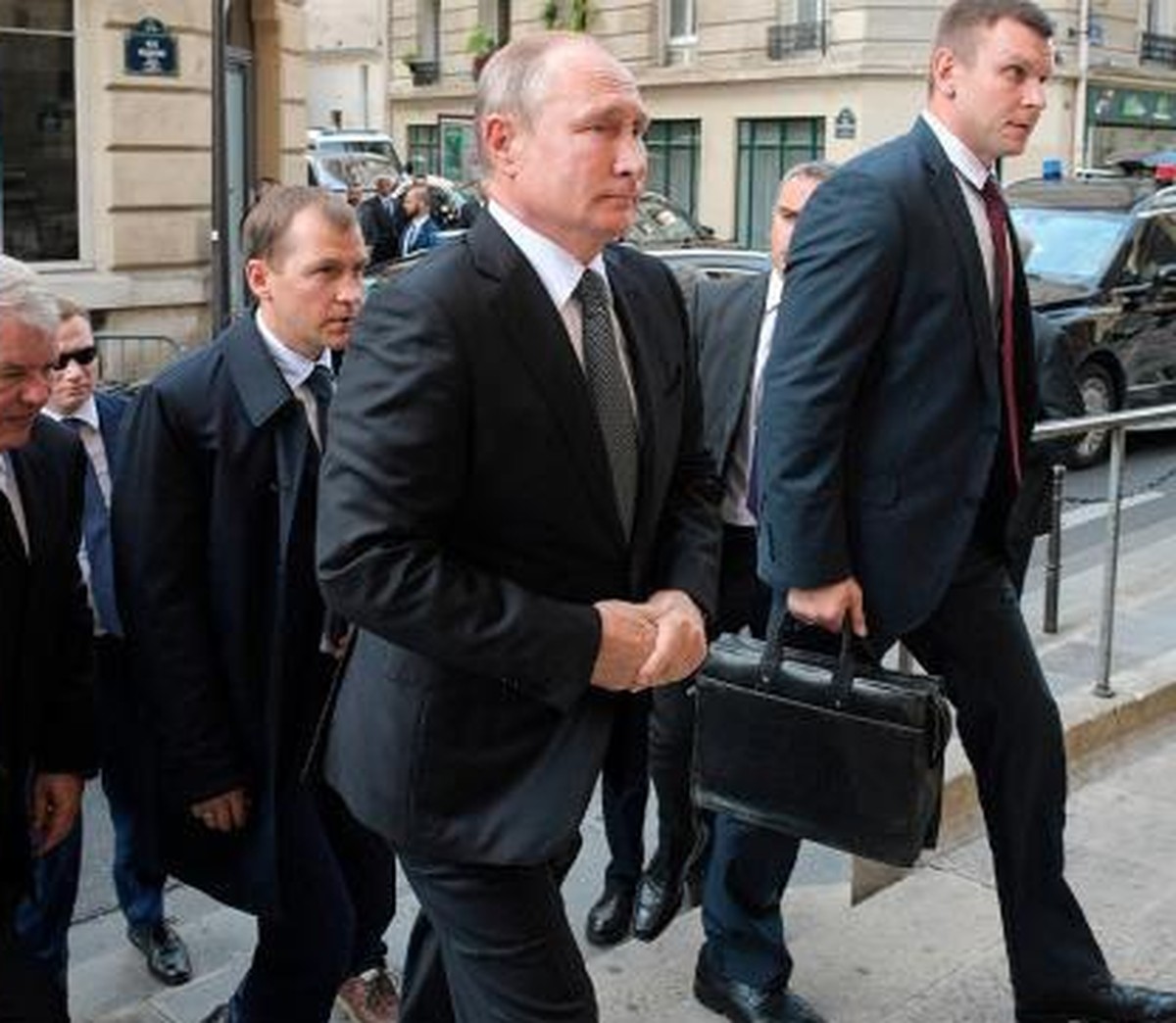 Vladimir Poutine et, à droite, l'homme avec la valise nucléaire.