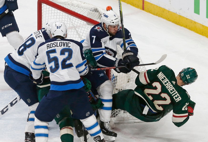 Winnipeg Jets&#039; Ben Chiarot (7) knocks Minnesota Wild&#039;s Nino Niederreiter (22) away from the net during the second period of Game 4 of an NHL hockey first-round playoff series Tuesday, April  ...