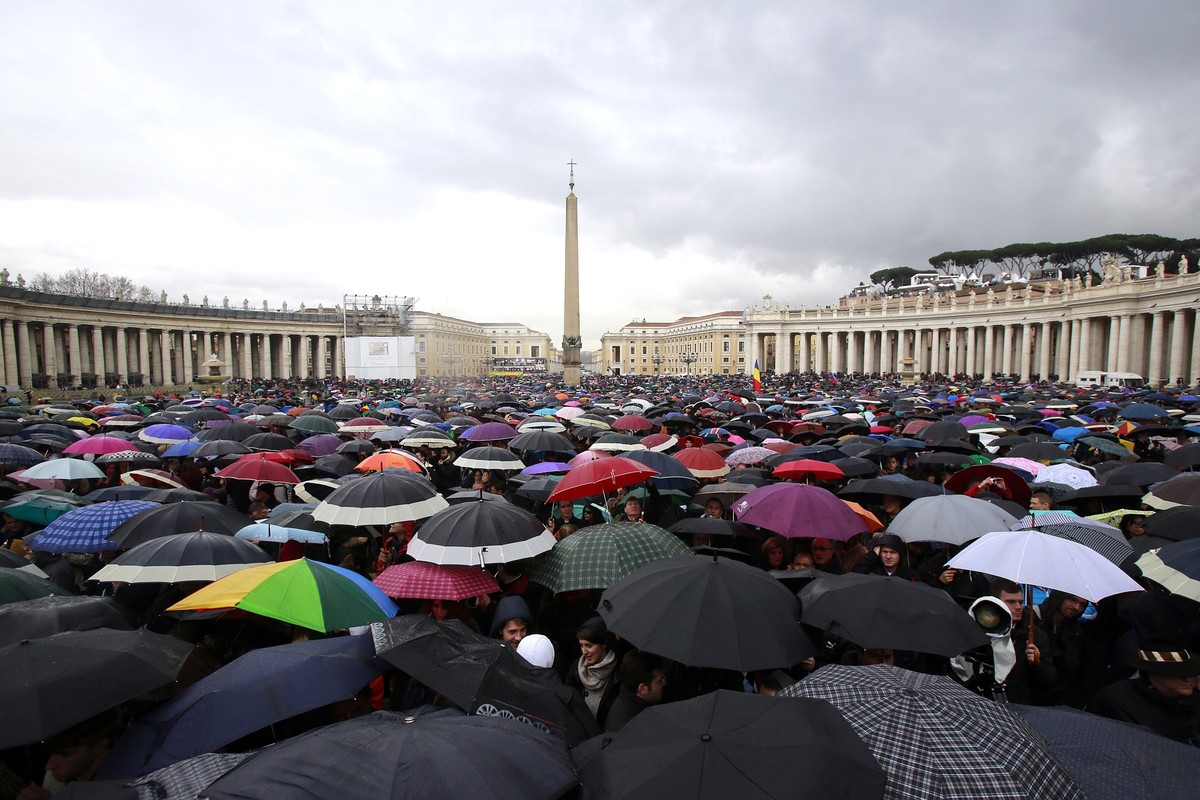 VATICAN CITY, VATICAN - MARCH 13: People shelter under umbrellas while they wait in St Peter's Square for news on the election of a new Pope on March 13, 2013 in Vatican City, Vatican. Pope Bened ...
