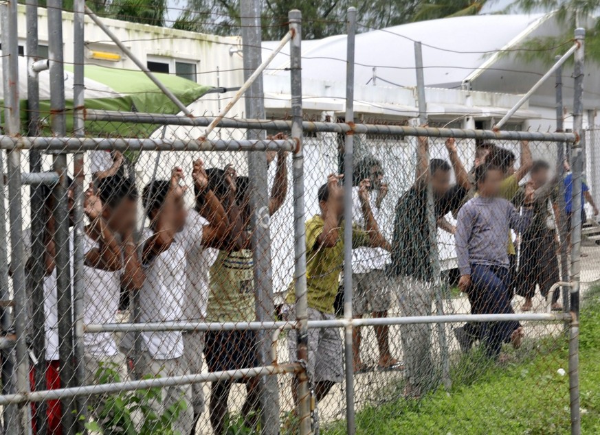 epa05492312 (FILE) A file picture dated dated 21 March 2014 shows asylum seekers behind a fence at the Manus Island detention center, in Papua New Guinea. Australia and paua New Guinea agreed to close ...