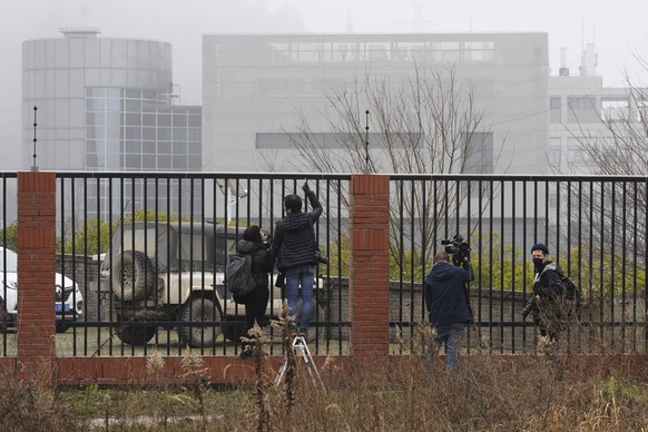 Journalists gather near an electric fence looking into the P4 Lab in the Wuhan Institute of Virology as the World Health Organization team visit on a field trip in Wuhan in China&#039;s Hubei province ...