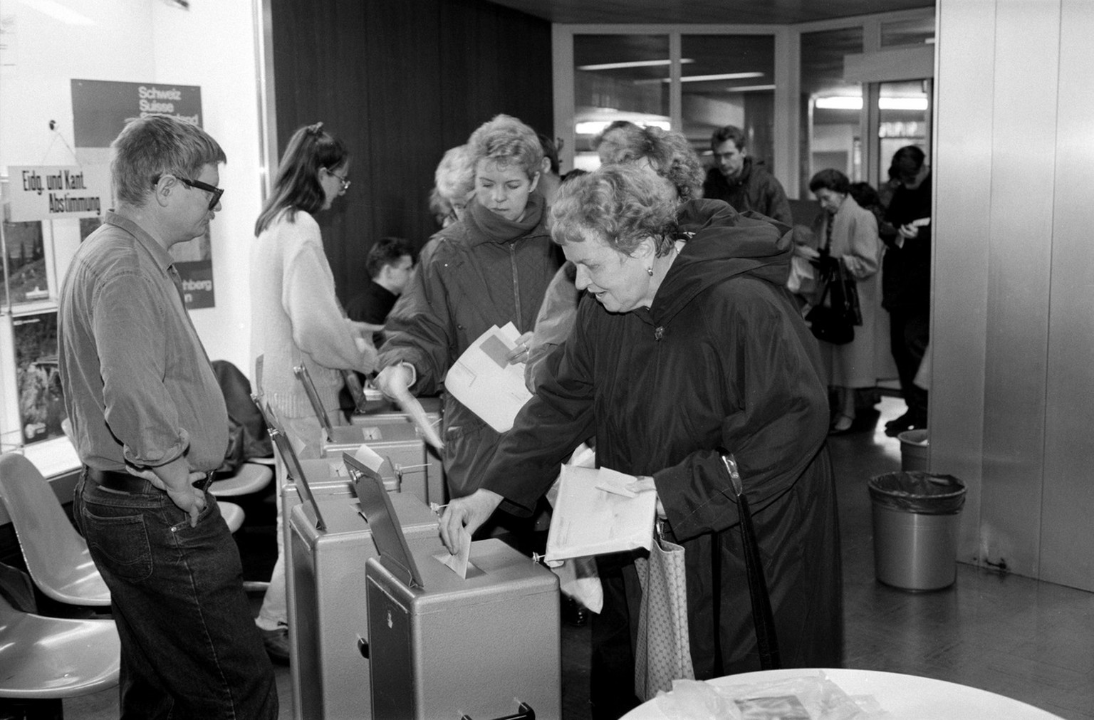 In einem Wahllokal am Hauptbahnhof von Bern werfen am 6. Dzember 1992 Buerger und Buergerinnen ihre Stimmzettel ueber einen Beitritt der Schweiz zum EWR in die Urnen. (KEYSTONE/Str)