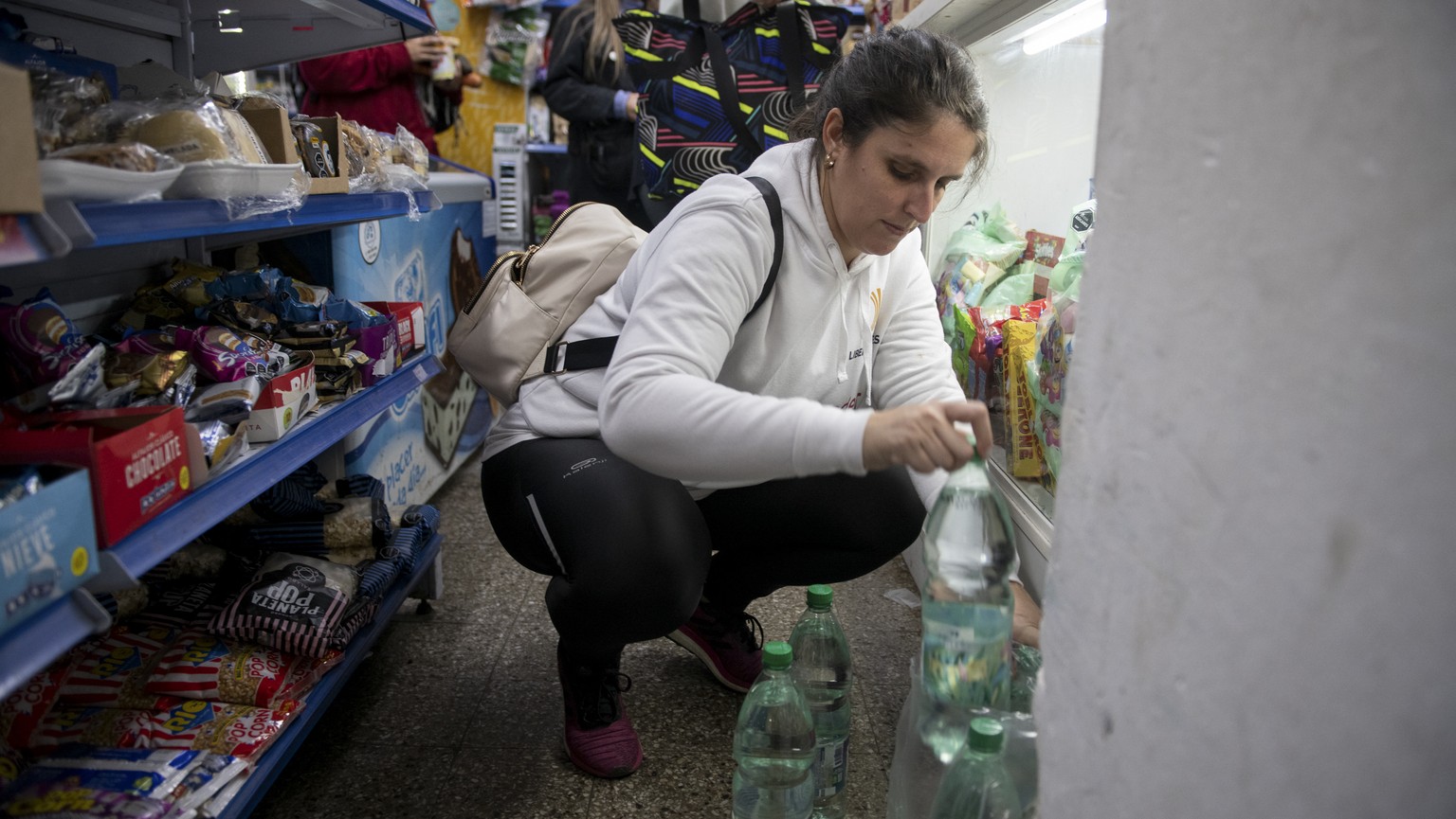 A woman buys bottled water at a supermarket in Montevideo, Uruguay, Monday, May 15, 2023. The ongoing drought in Uruguay has led to significant salinization of drinking water in Montevideo and the met ...