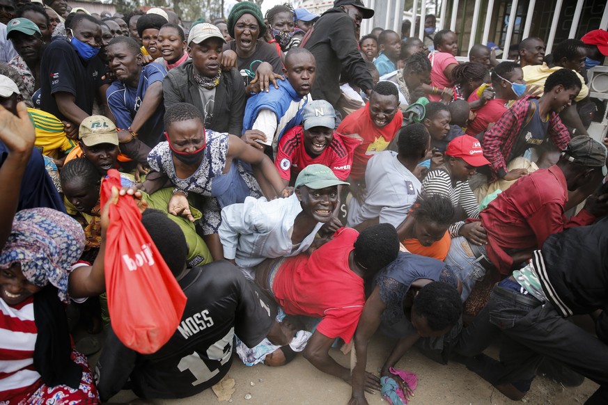 Residents desperate for a planned distribution of food for those suffering under Kenya&#039;s coronavirus-related movement restrictions push through a gate and create a stampede, causing police to fir ...