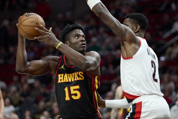 Atlanta Hawks center Clint Capela, left, shoots over Portland Trail Blazers center Deandre Ayton during the first half of an NBA basketball game in Portland, Ore., Wednesday, March 13, 2024. (AP Photo ...