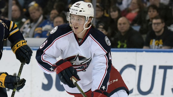 Buffalo Sabres center Sam Reinhart (23) pursues as Columbus Blue Jackets defenseman Dean Kukan (46), of the Czech Republic, looks to pass the puck up ice during the first period of an NHL hockey game, ...