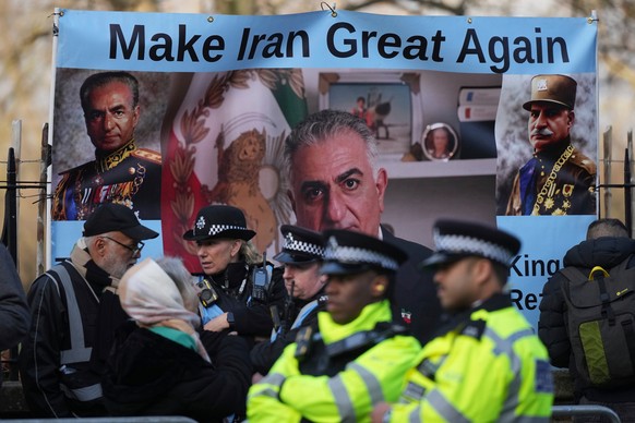Police speak to demonstrators as they hold placards, banner and flags as they protest outside the Iranian Embassy in London, Friday, Jan. 16, 2026. (AP Photo/Alastair Grant)
Britain Iran Protests