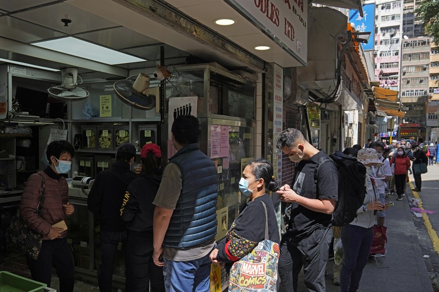 People wearing face masks line up to buy noodles at a local market in Hong Kong, Tuesday, March 8, 2022. The fast-spreading omicron variant is overwhelming Hong Kong, prompting mass testing, quarantin ...