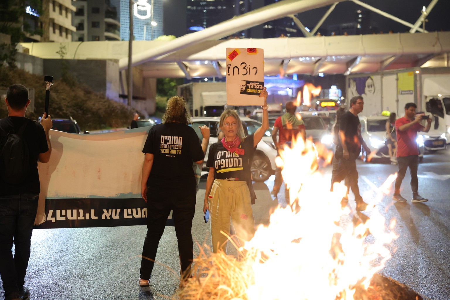 epa11644250 Protesters block Ayalon highway and set up a bonfire calling for a ceasefire and for the release of Israeli hostages held by Hamas in Gaza, near the Kirya in Tel Aviv, Israel, 05 October 2 ...