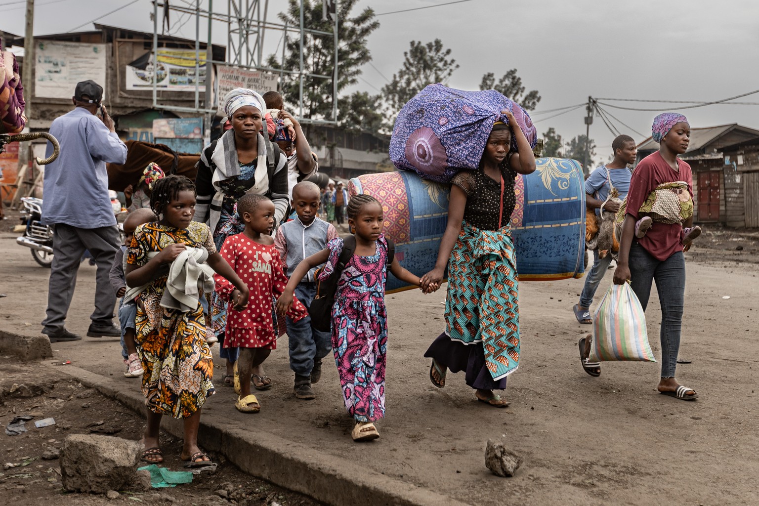 epa11854866 People carry their belongings as they flee the fightings between the M23 rebels and the Armed forces of the Democratic Republic of Congo (FARDC), in Mugini, North Kivu province, Democratic ...