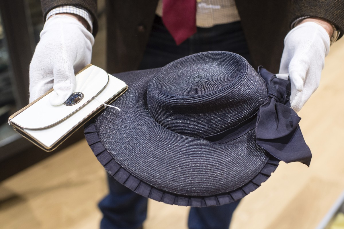 An empolyee holds a wallet and a strawhat that belonged to Eva Braun the wife of Adolf Hitler prior to an auction in Grasbrunn, Germany, Wednesday, Nov. 20, 2019. A Jewish group has sharply condemned  ...