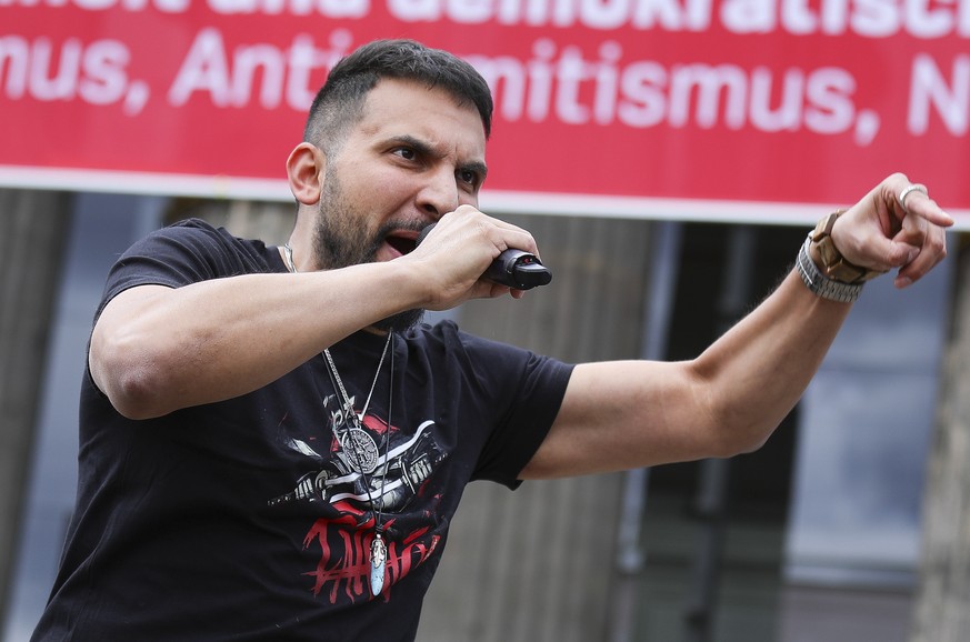 epa08540647 German vegan chef Attila Hildmann, speaks to his followers during an anti-restrictions protest at the Lustgarten park in Berlin, Germany, 11 July 2020. Hildmann supporters demonstrate main ...