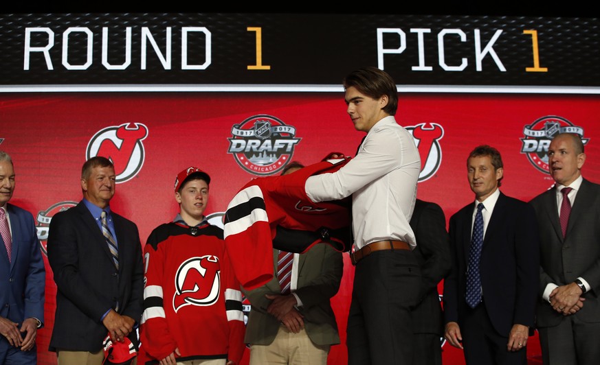 Center Nico Hischier, chosen by the New Jersey Devils in the first round of the NHL hockey draft, puts on a jersey Friday, June 23, 2017, in Chicago. (AP Photo/Nam Y. Huh)