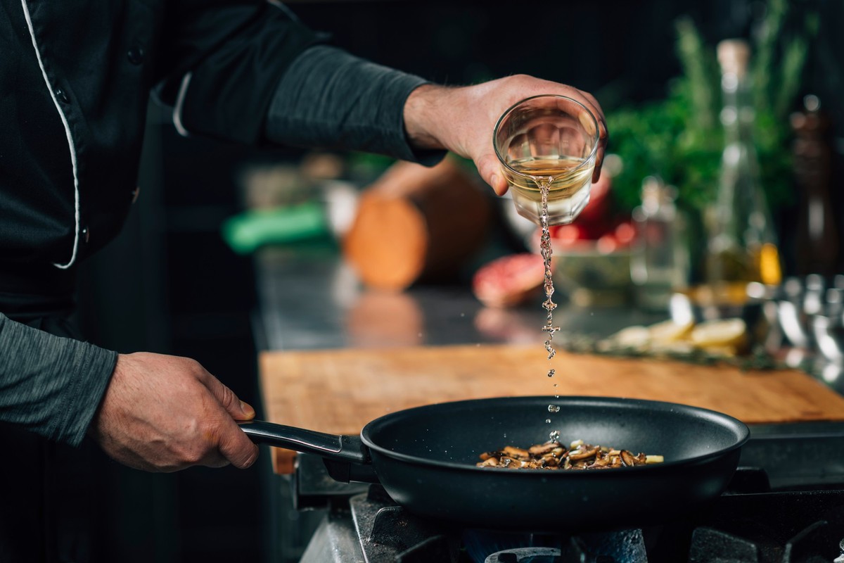 Mann Kochen Weisswein ablöschen