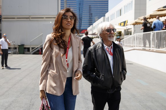 epa07531557 Former Formula One chairman Bernie Ecclestone (R) with his wife Fabiana Flosi (L) walk through the paddock at the Baku City Circuit in Baku, Azerbaijan, 27 April 2019. The 2019 Formula One ...