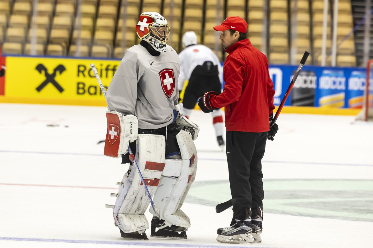 Patrick Fischer, head coach of Switzerland national ice hockey team, talks with Switzerland's goaltender Leonardo Genoni, left, during a Switzerland team training session at the IIHF 2025 World C ...