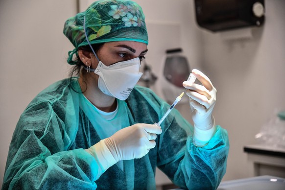 epa08920773 A healthcare worker prepares a syringe with a dose of the Pfizer-BioNTech vaccine at the Villa Scassi Hospital in Genoa, Italy, 05 January 2021. A second batch of 470,000 doses of the Pfiz ...