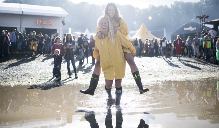 epa06058495 Visitors walk in a puddle during the 41st Openair St. Gallen music festival, in St. Gallen, Switzerland, 30 June 2017. The festival runs from 29 June to 02 July. EPA/ENNIO LEANZA