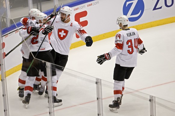 Switzerland&#039;s forward Enzo Corvi, left, celebrates his gaol with teammate forward Nino Niederreiter, 2nd left, defender Roman Josi, 2nd right, and defender Dean Kukan, right, after scoring the 1: ...