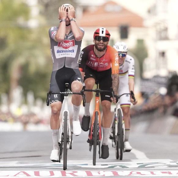 Mathieu van der Poel reacts as he crosses the finish line in first place, with Filippo Ganna on second place, centre, and Tadej Pogacar, right, on third place of the men's elite race of the Milan ...